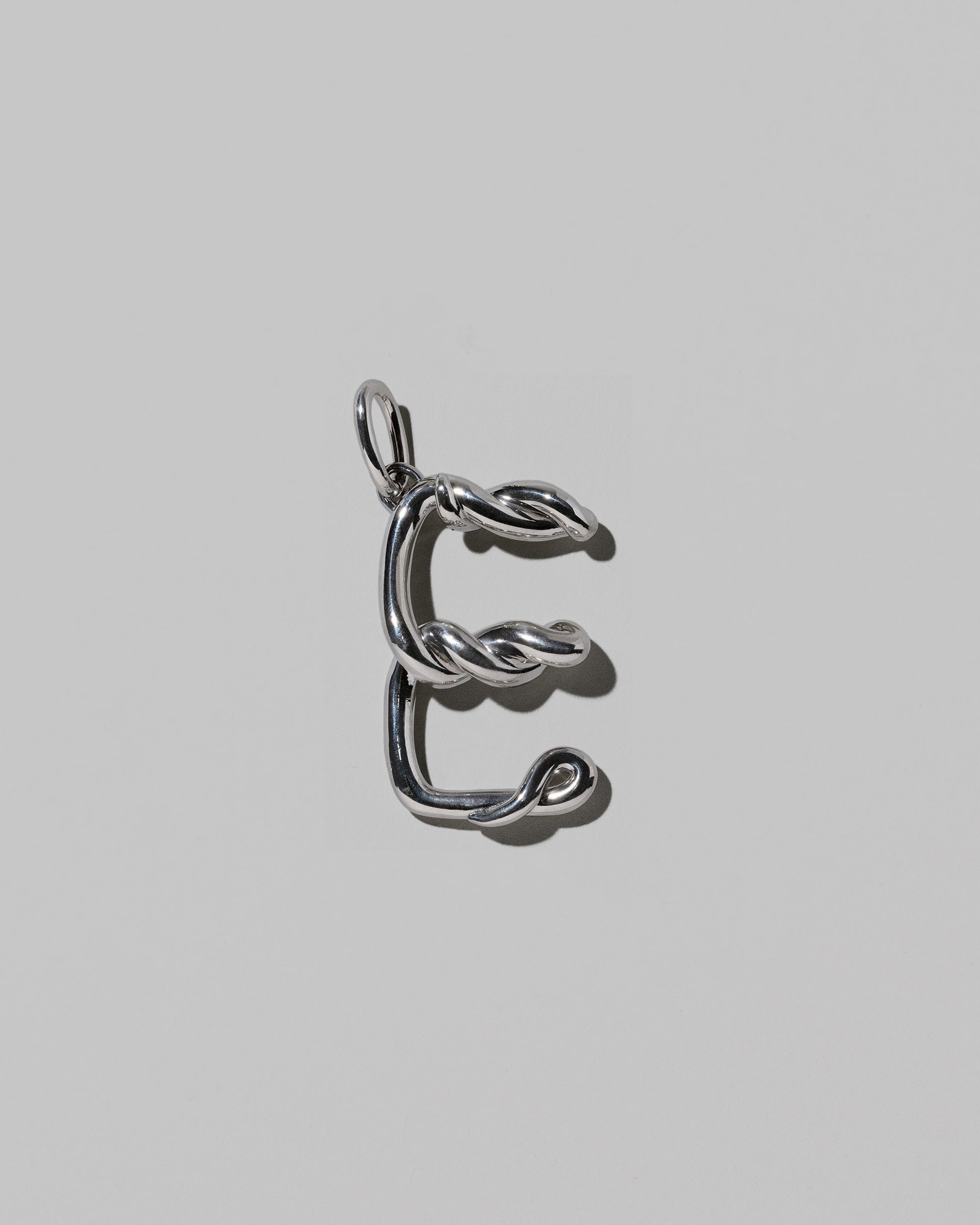 CRZM Large Letter E Charm set in sterling silver on light color background.