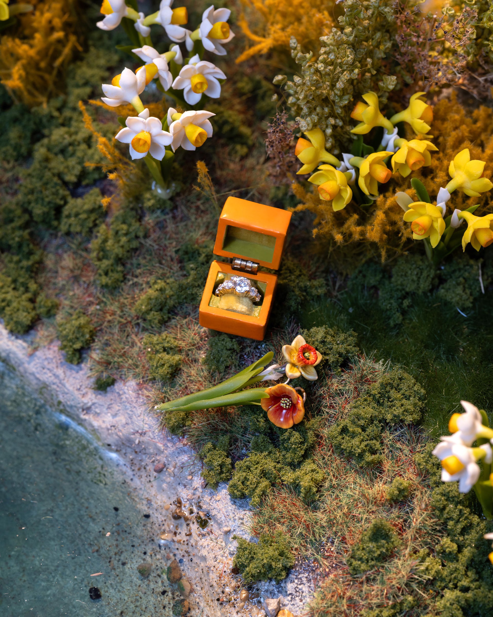 Styled image featuring the California Poppy Charm, with the Daffodil Charm and Luna Ring Charm.