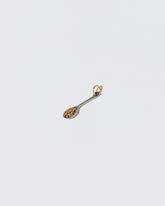 View from the side of the Cereal Spoon Charm on light color background.