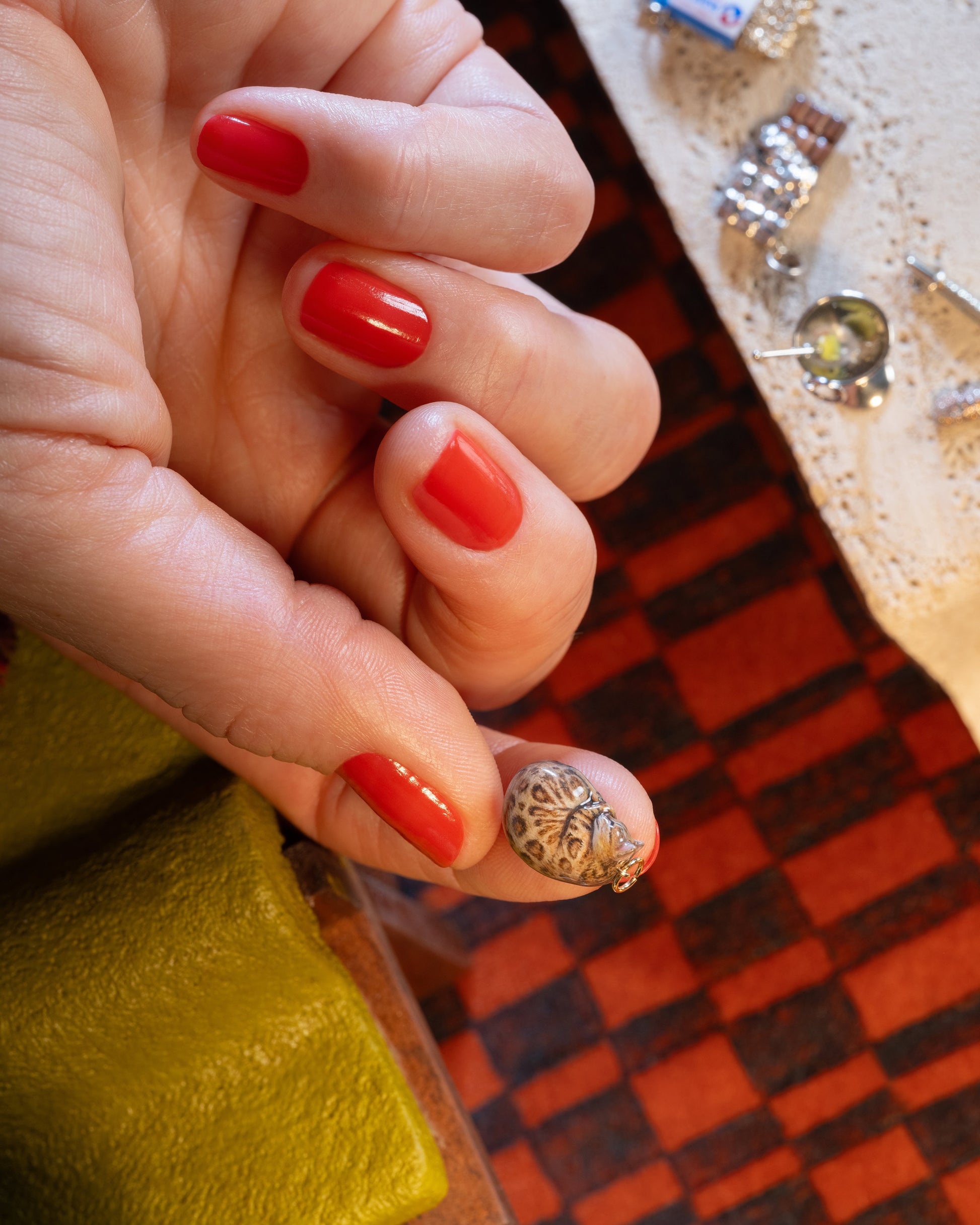 Styled image of the Curled-Up Cat Charm, with the Dirty Martini Charm and Chocolate Bar Charm.