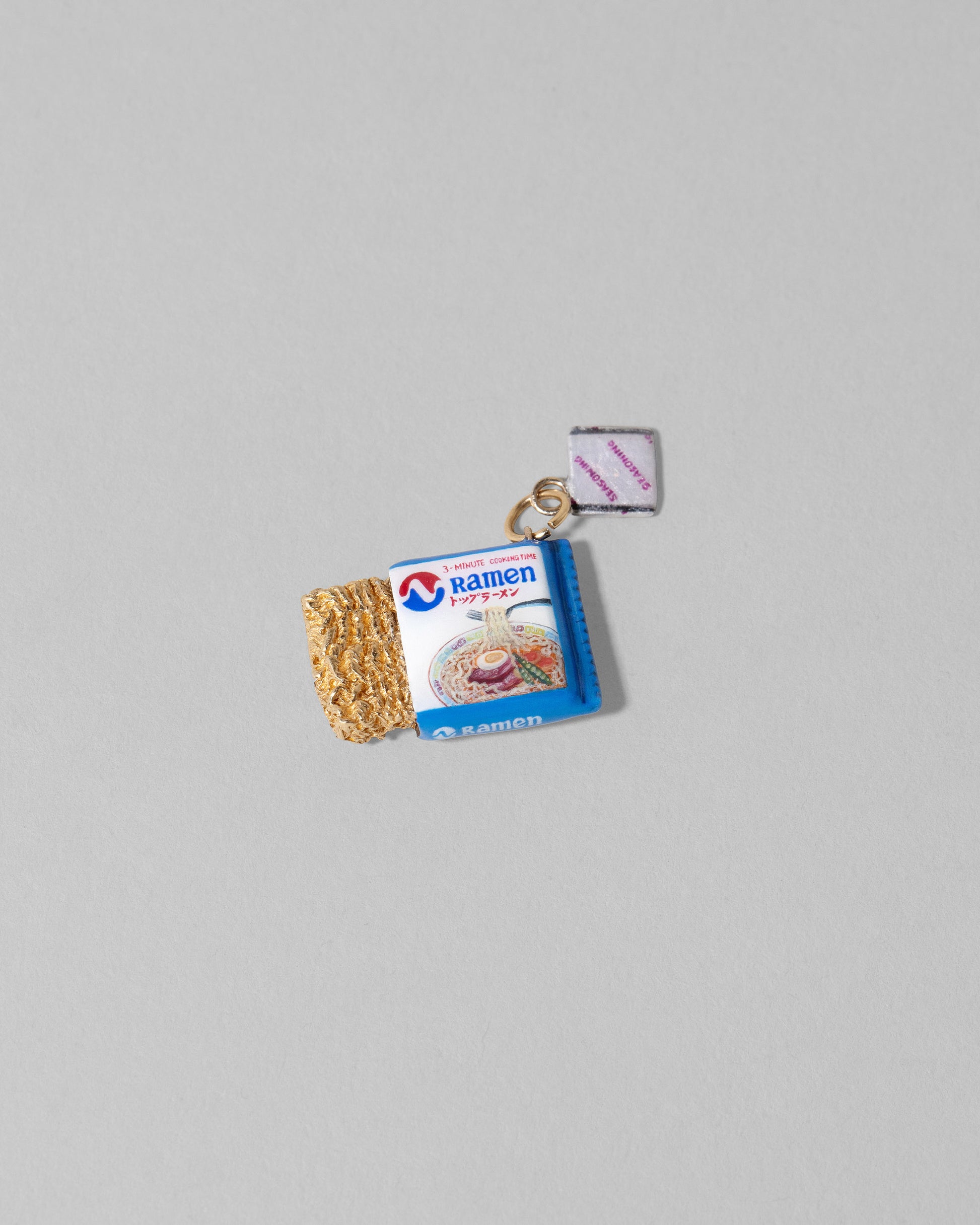 Closeup details of the Instant Ramen Charm on light color background.