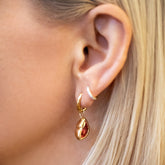 product_details::Red Lover's Kiss Charm and Classic Gold Solid Snack Hoop Earrings with Huggie Gold Diamond Snack Hoop Earrings on model.