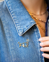 Spiral Pin Brooch with Loop & Sphere Talisman Charm, Eye Talisman Charm, Gold Small Thousand & One Night Heart Charm, North Star Talisman Charm and Sardine Fish Charm on model.