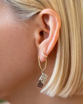 Chocolate Bar Charm paired with Solid Tiny Loop Hoop Earrings and styled with Huggie Gold Diamond Snack Hoop Earrings on model.