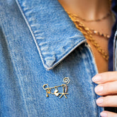 product_details::Spiral Pin Brooch with Loop & Sphere Talisman Charm, Eye Talisman Charm, Gold Small Thousand & One Night Heart Charm, North Star Talisman Charm and Sardine Fish Charm on model.