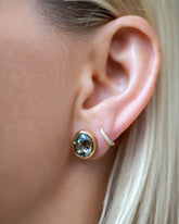 Juniper Stud Earrings styled with Huggie Gold Diamond Snack Hoop Earrings on model.