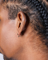 Gold Snow Flower Huggie Hoop Earrings on male model.