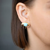 product_details::Turquoise Eye Earrings on model.