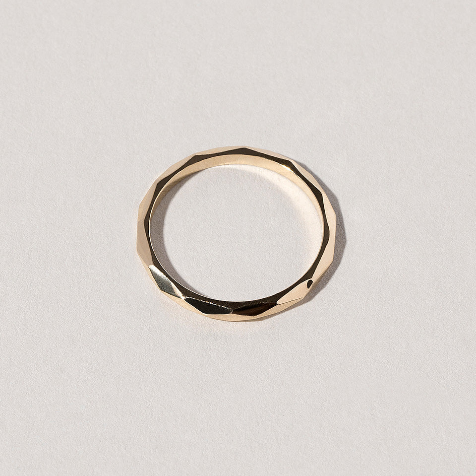 product_details::Gold 2mm Facet Band on light color background.