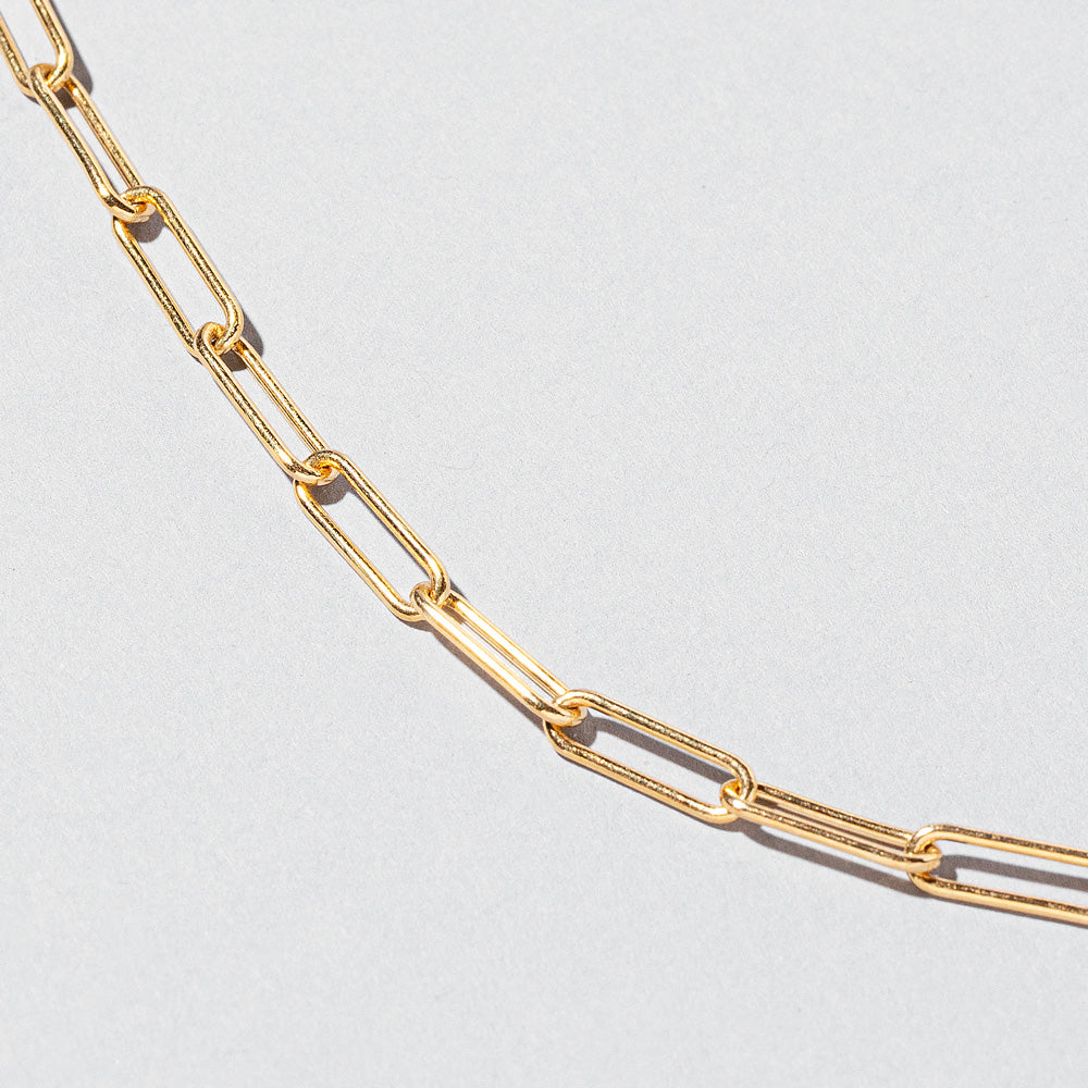 product_details::Closeup details of the Long Oval Chain Bracelet on light color background.