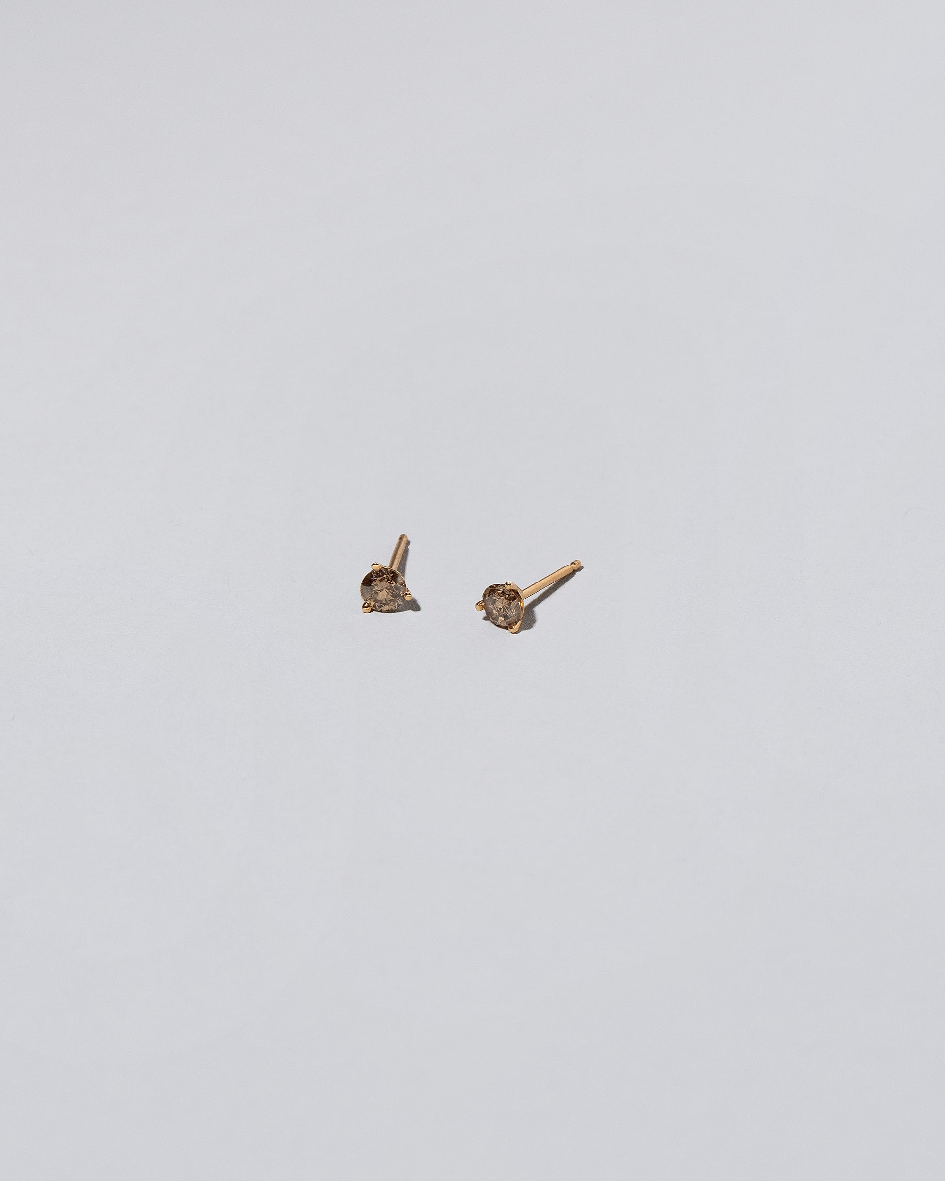 Cognac Diamond Martini Stud Earrings on light color background.