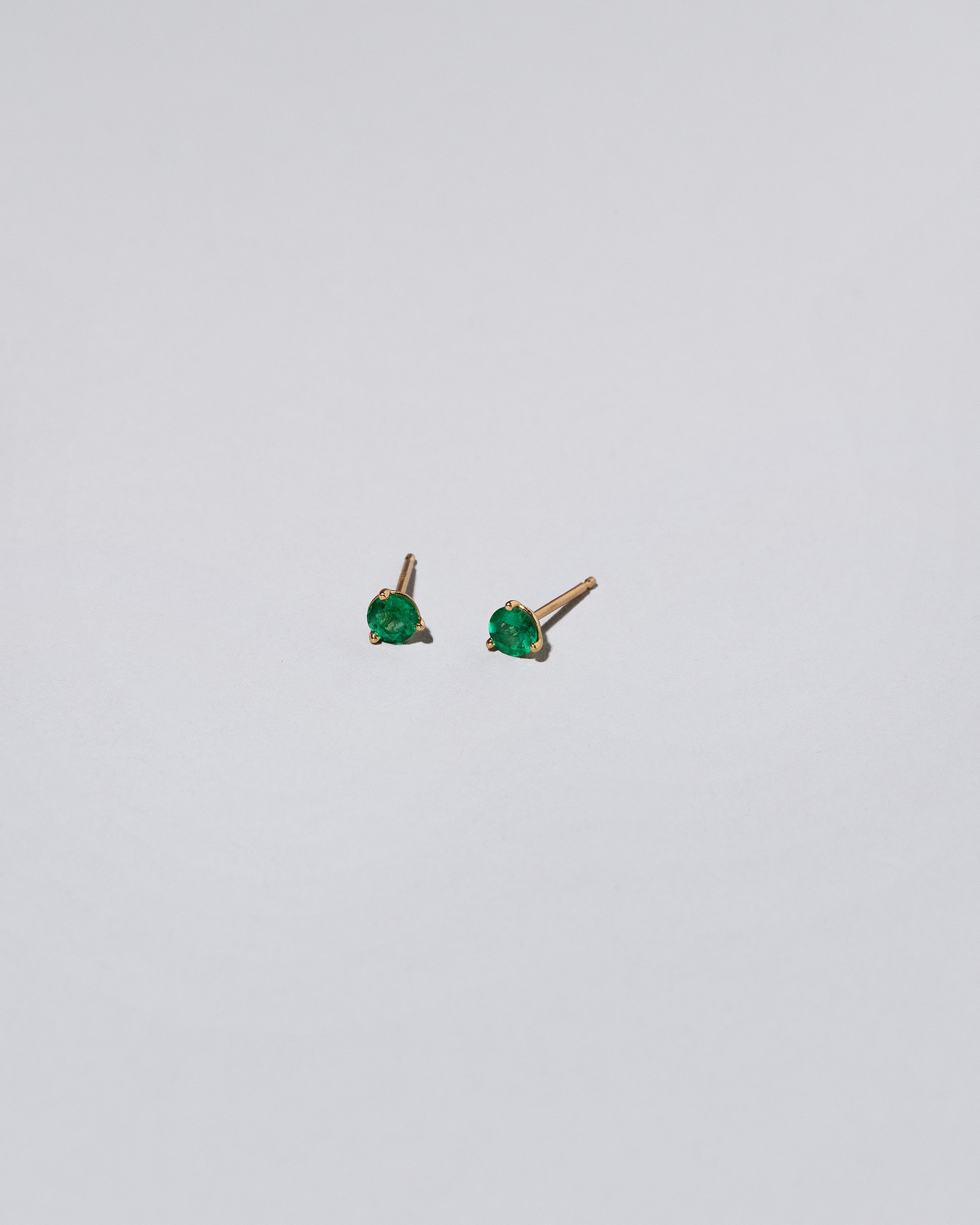 Emerald Martini Stud Earrings on light color background.