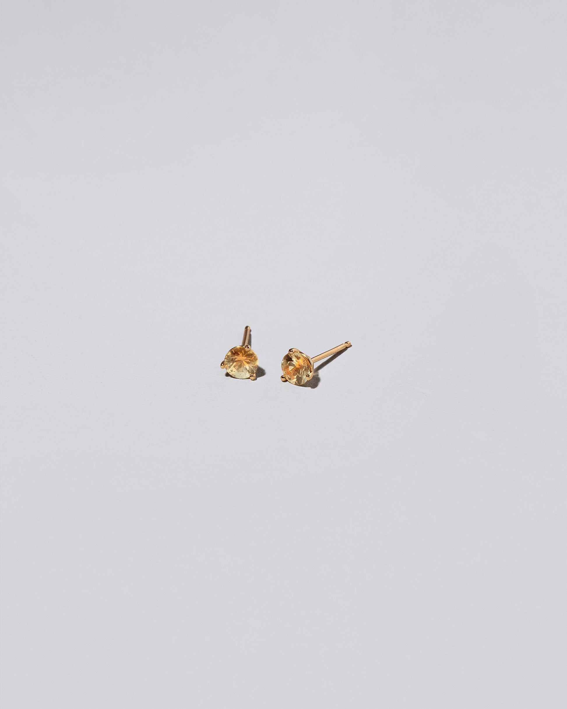 Kaleidoscope Yellow Sapphire Martini Stud Earrings on light color background.