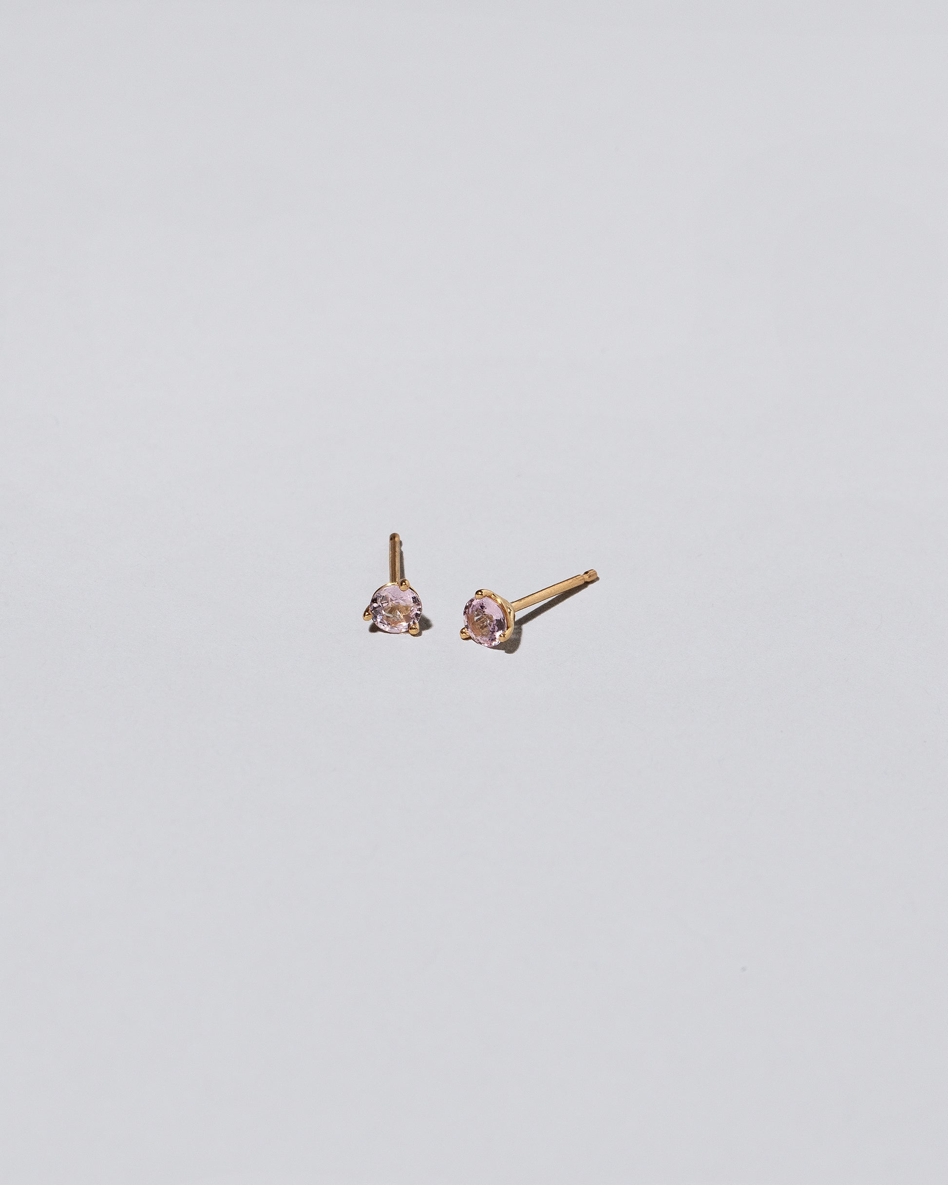 Light Pink Sapphire Martini Stud Earrings on light color background.