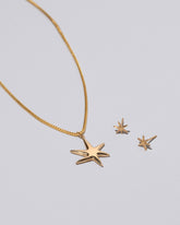 Gold Stars Necklace & Studs Set on light color background.