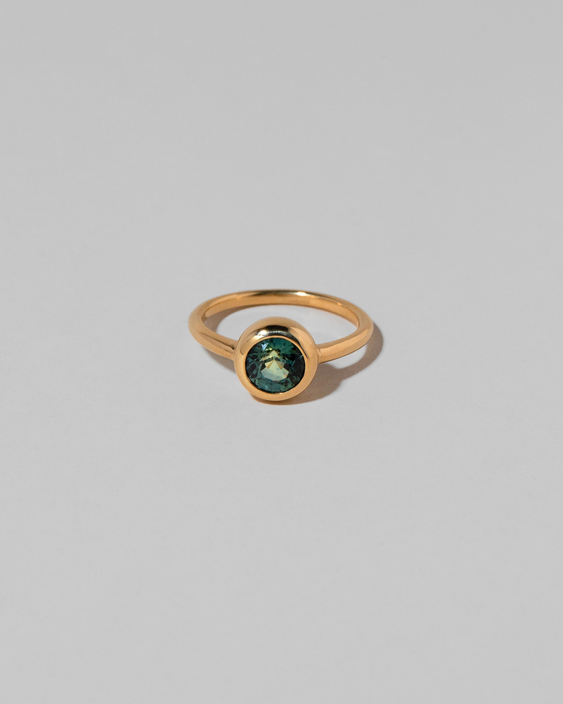 Teal Sapphire Wellspring Ring on light color background.