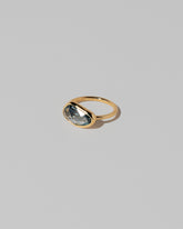 View from the side of the Gusher Teal Sapphire Ring 037 on light color background.