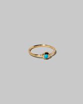 View from the side of the Turquoise Cabochon Birthstone Level Ring on light color background.