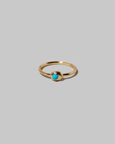 Turquoise Cabochon Birthstone Level Ring on light color background.