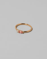 View from the side of the Peach Sapphire Teardrops Ring on light color background.