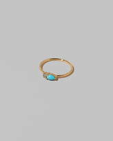 View from the side of the Turquoise Teardrops Ring on light color background.
