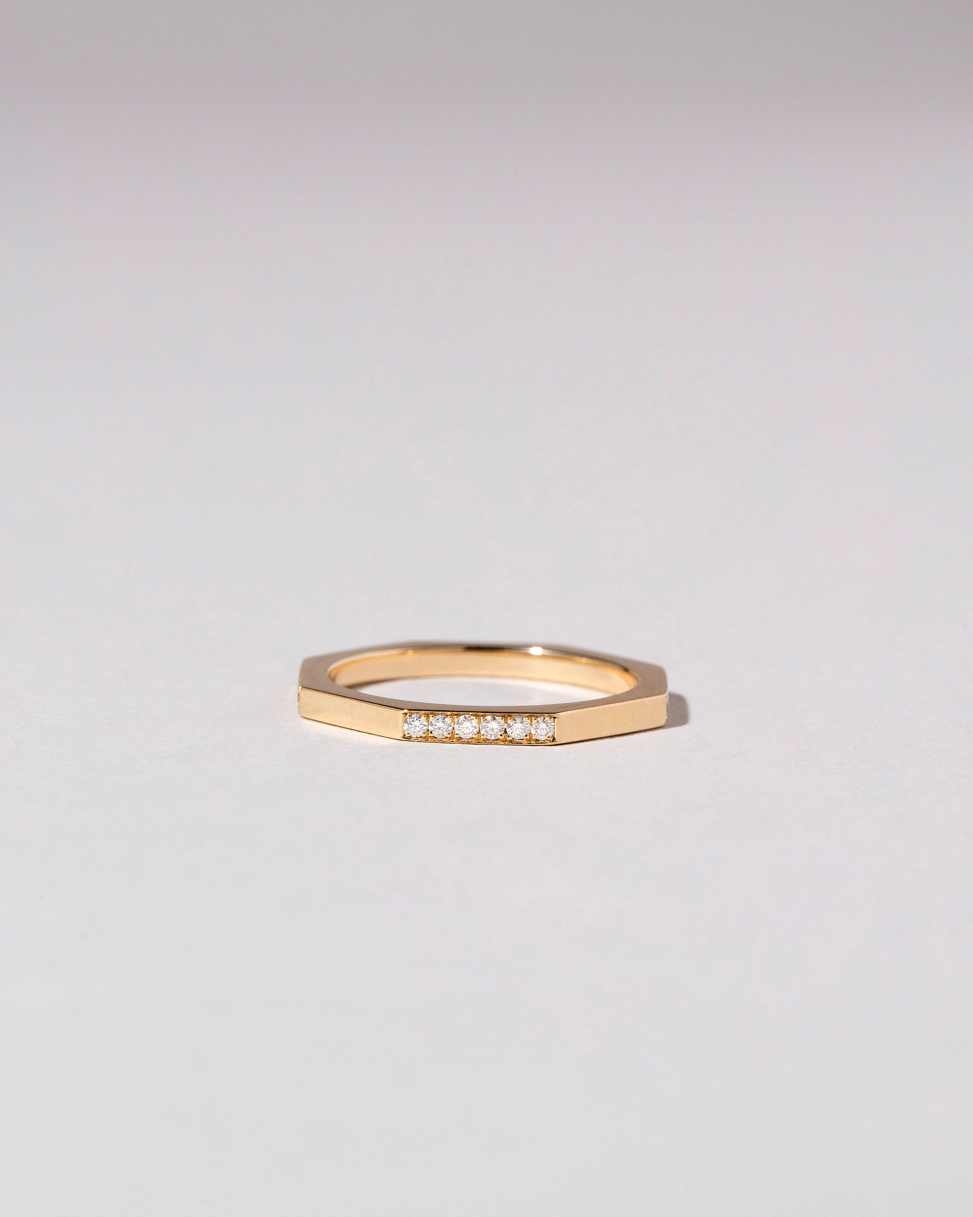 Gold 1.7mm Single Side Pavé Segmented Band on light color background.