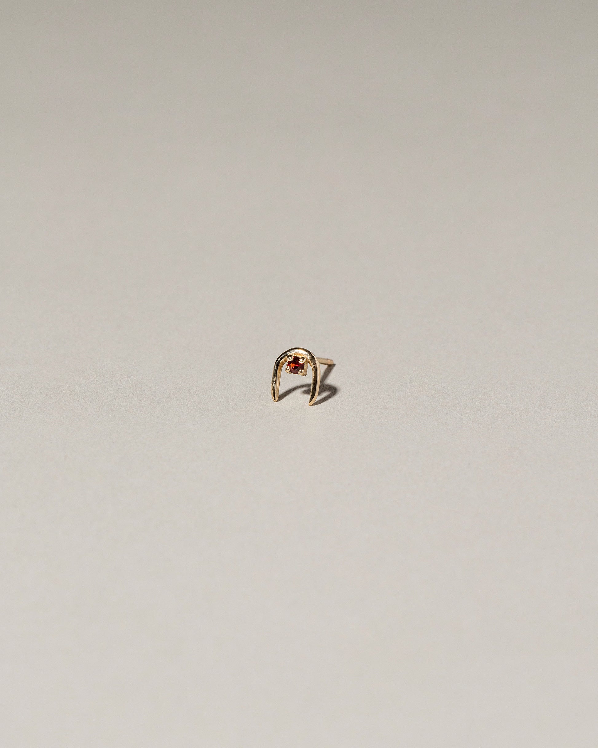 Garnet Moon Catcher Stud Earring Single on light color background.