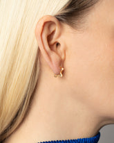 Gold Snow Flower Huggie Hoop Earrings on model.