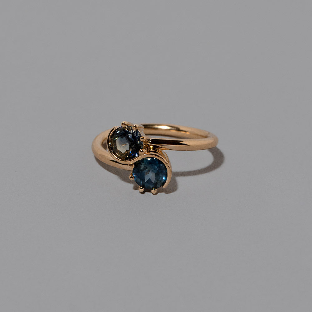 product_details::Closeup details of the Sapphire Sun & Moon Union Ring on light color background.