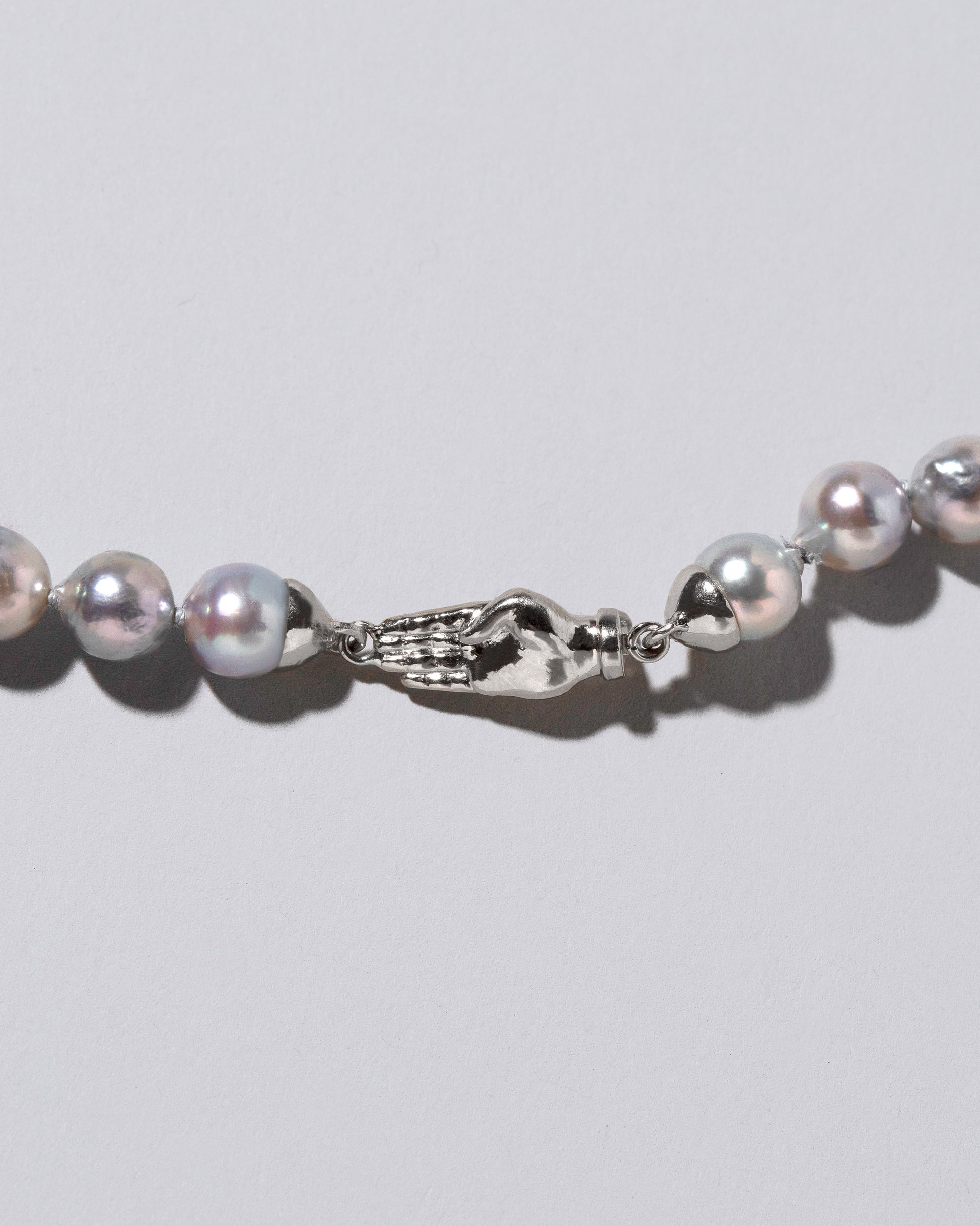 Closeup detail of the Blue Pearl & White Gold Union Pearl Necklace on light color background.