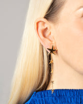 Styled image of model wearing the Verve Star Shoulder Duster Earrings.