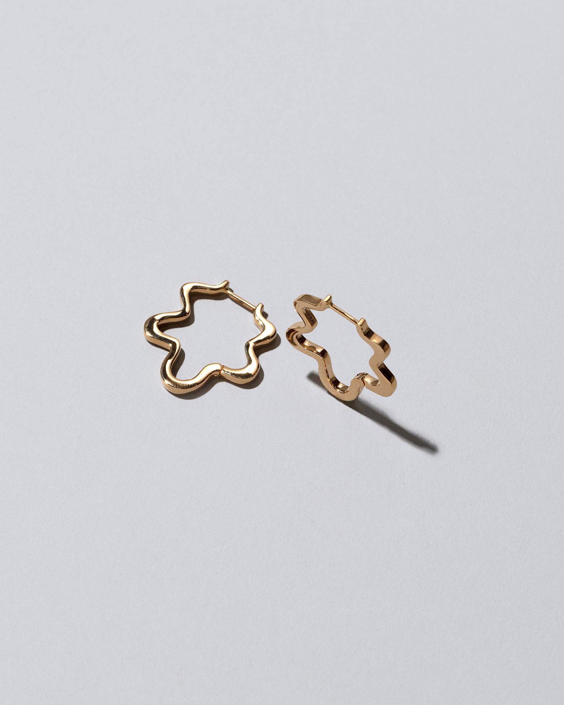Closeup details of the Gold Wild Poppies Hoop Earrings on light color background.