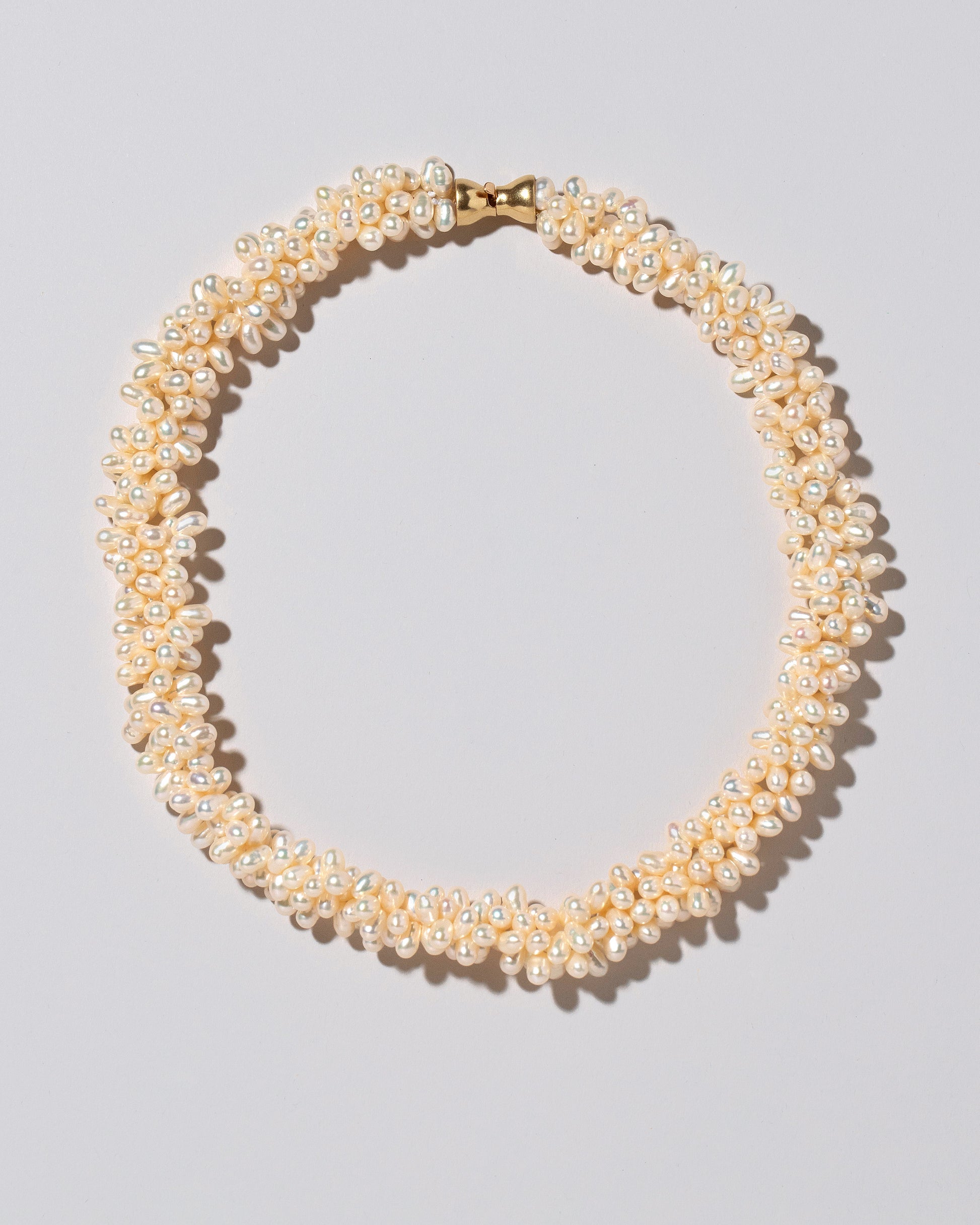Push Clasp Braided Zipper Pearl Collar Necklace on light color background.