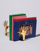 Detail view of the Carl Auböck Pair of Jazz Hands Brass Bookends Set on light color background.