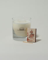 Closeup details of the Ranger Station Leather & Pine Candle with matchbox on light color background.