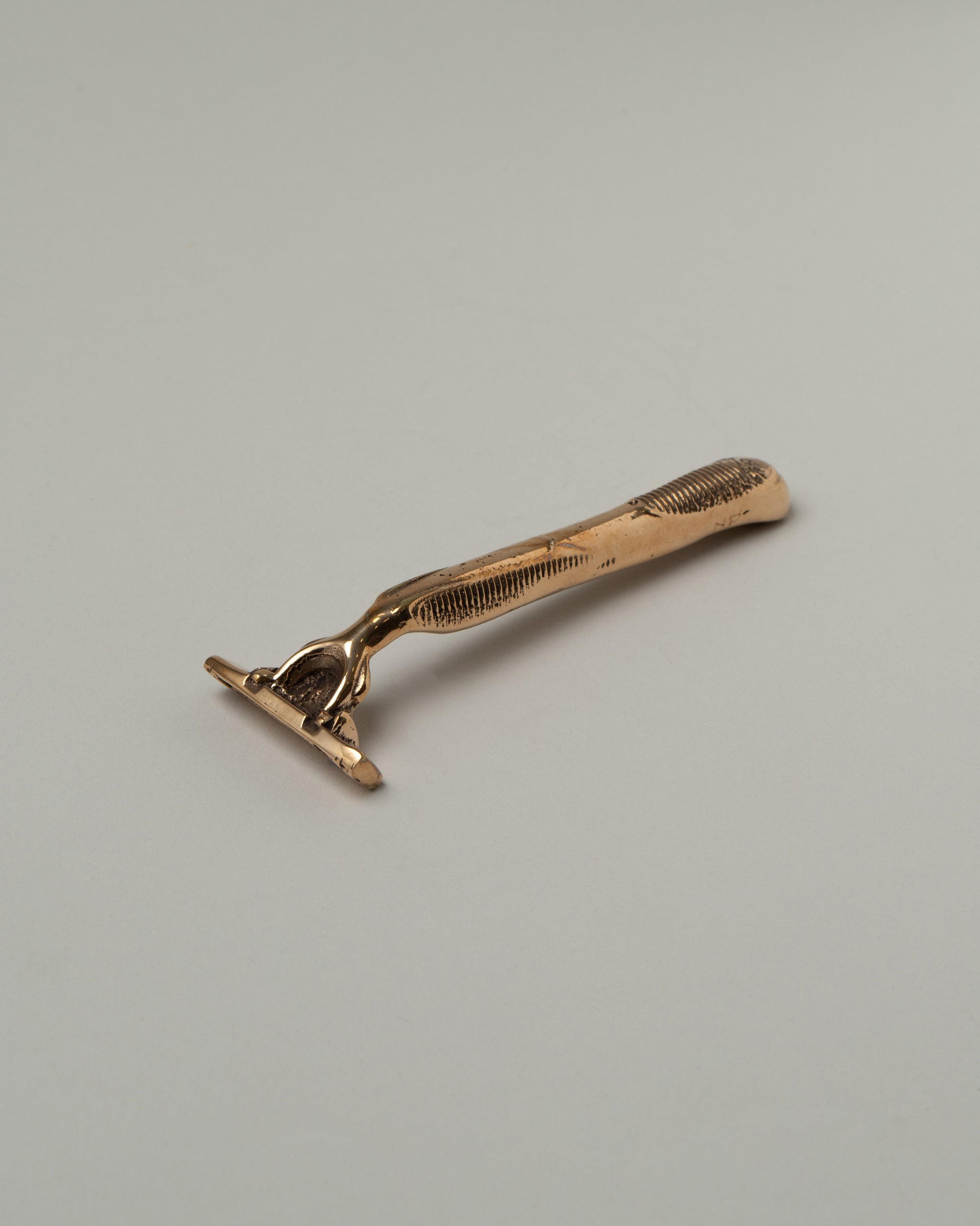 Pearce Objects Cast Bronze Razor on light color background.