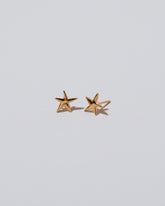 Closeup details of the Shape One Small Verve Five Point Star Stud Earrings on light color background.