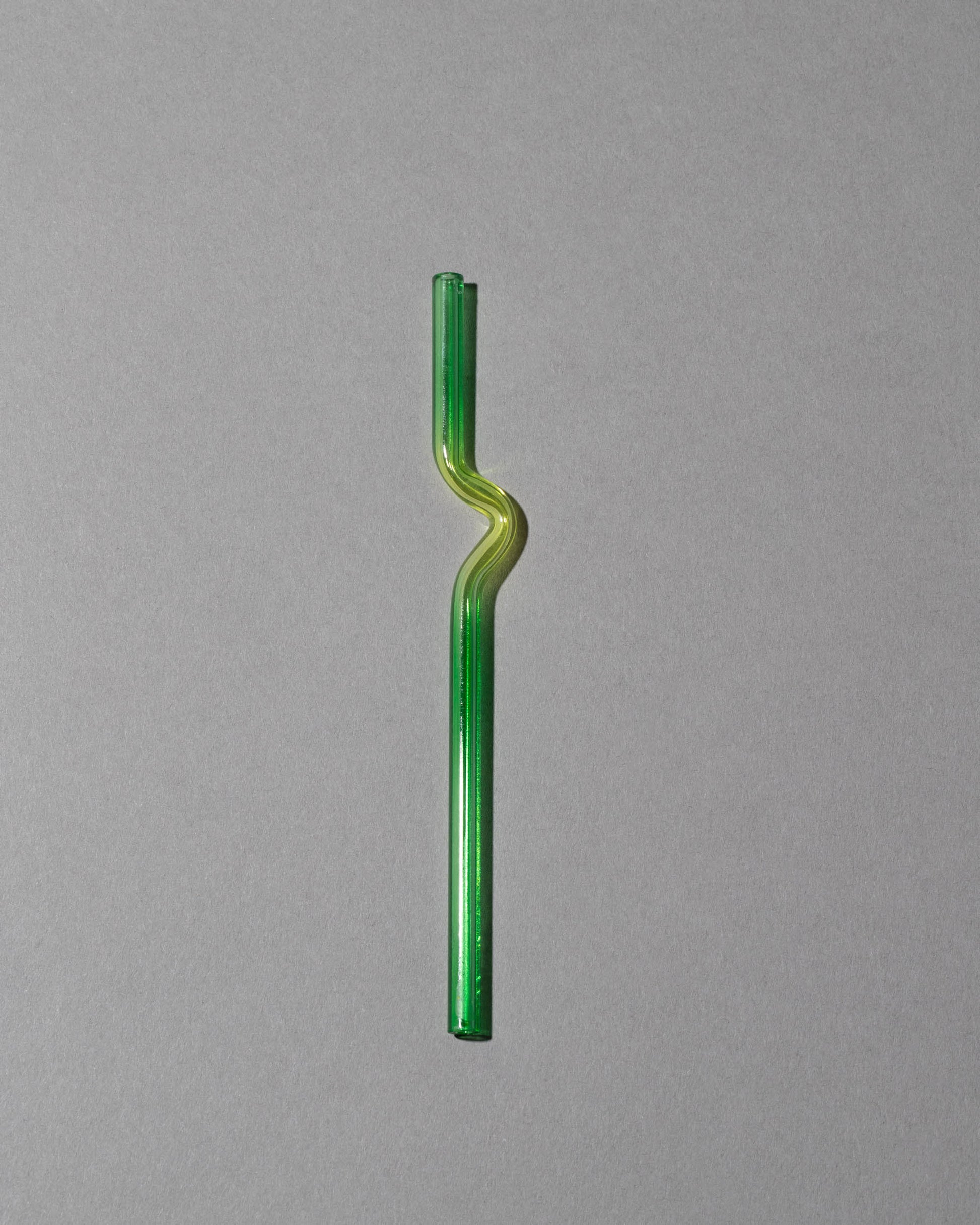 Misha Kahn Yellow and Green Suck It Up Glass Cocktail Straw on light color background.