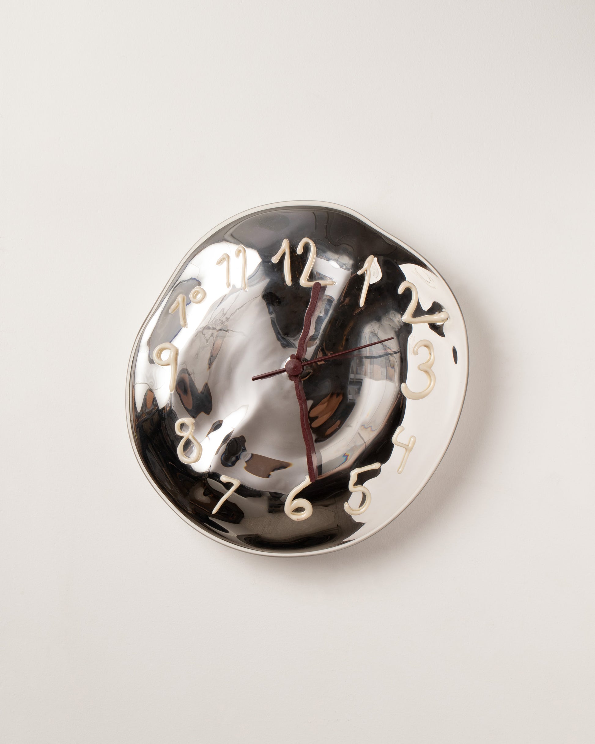 Silje Lindrup Brown Hands White Glass Wall Clock on light color background.