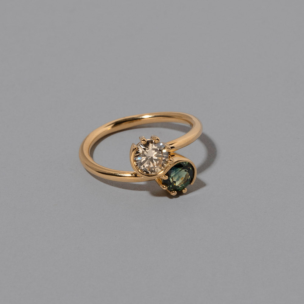 product_details::Closeup details of the Sapphire & Champagne Diamond Sun & Moon Union Ring on light color background.