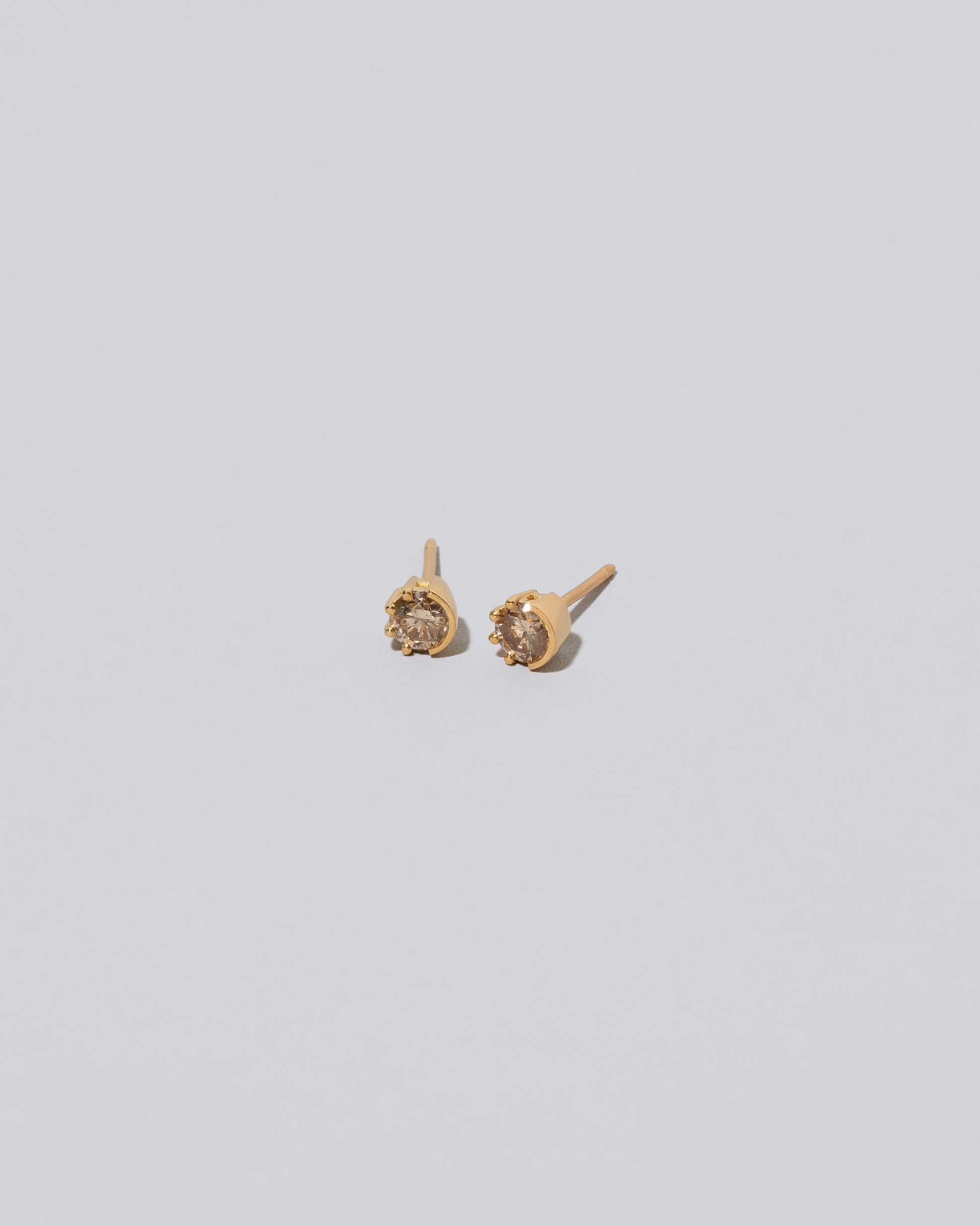 Champagne Diamond Sun & Moon Stud Earrings on light color background.