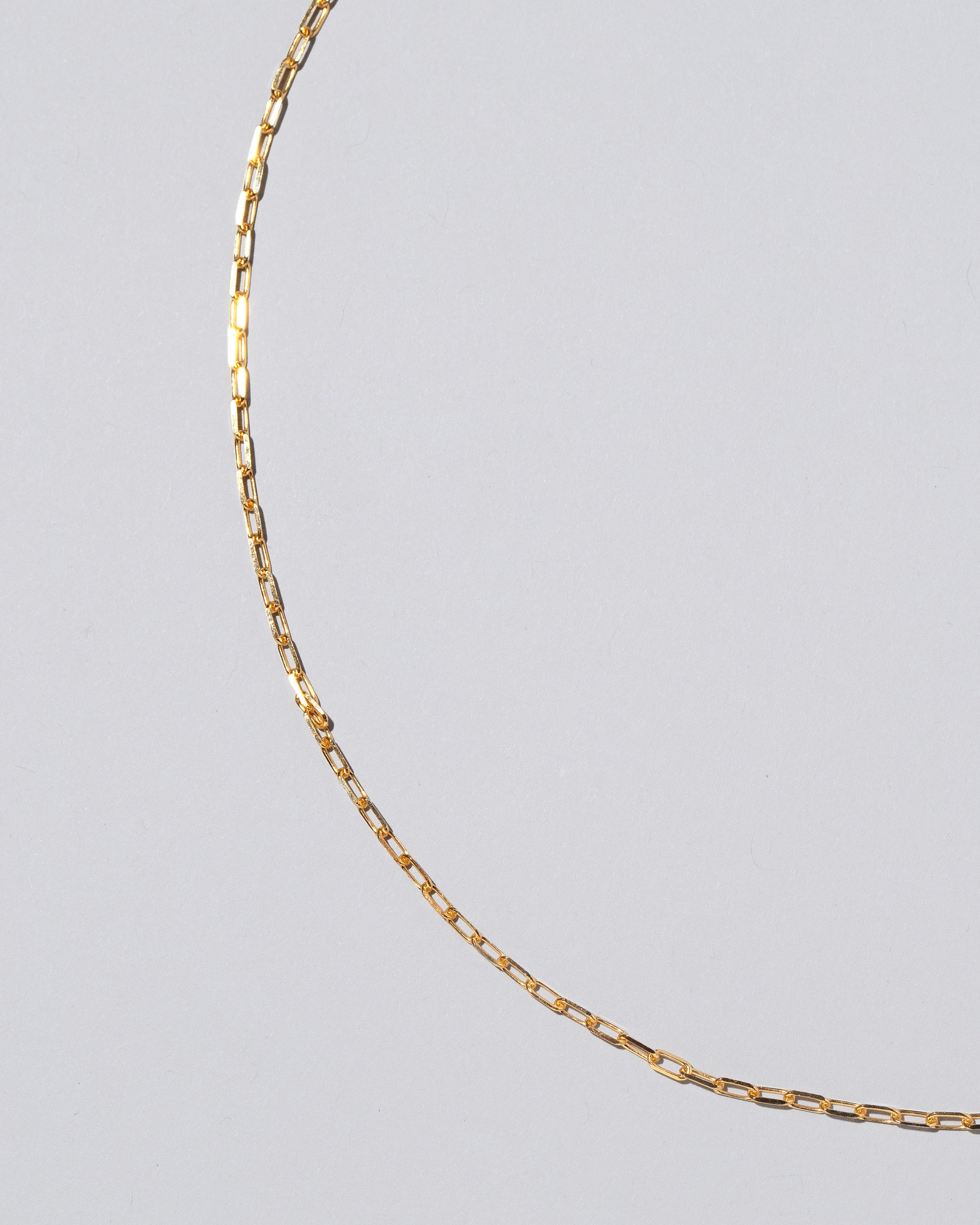 Closeup detail of the 2.2mm Beveled Oval Chain Necklace on light color background.