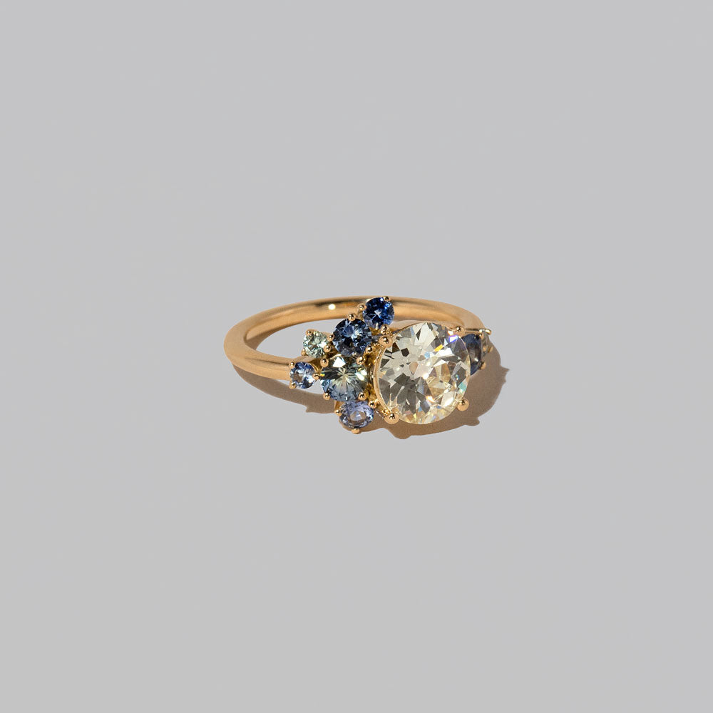 product_details::Closeup details of the Diamond & Sapphire Vega Ring on light color background.