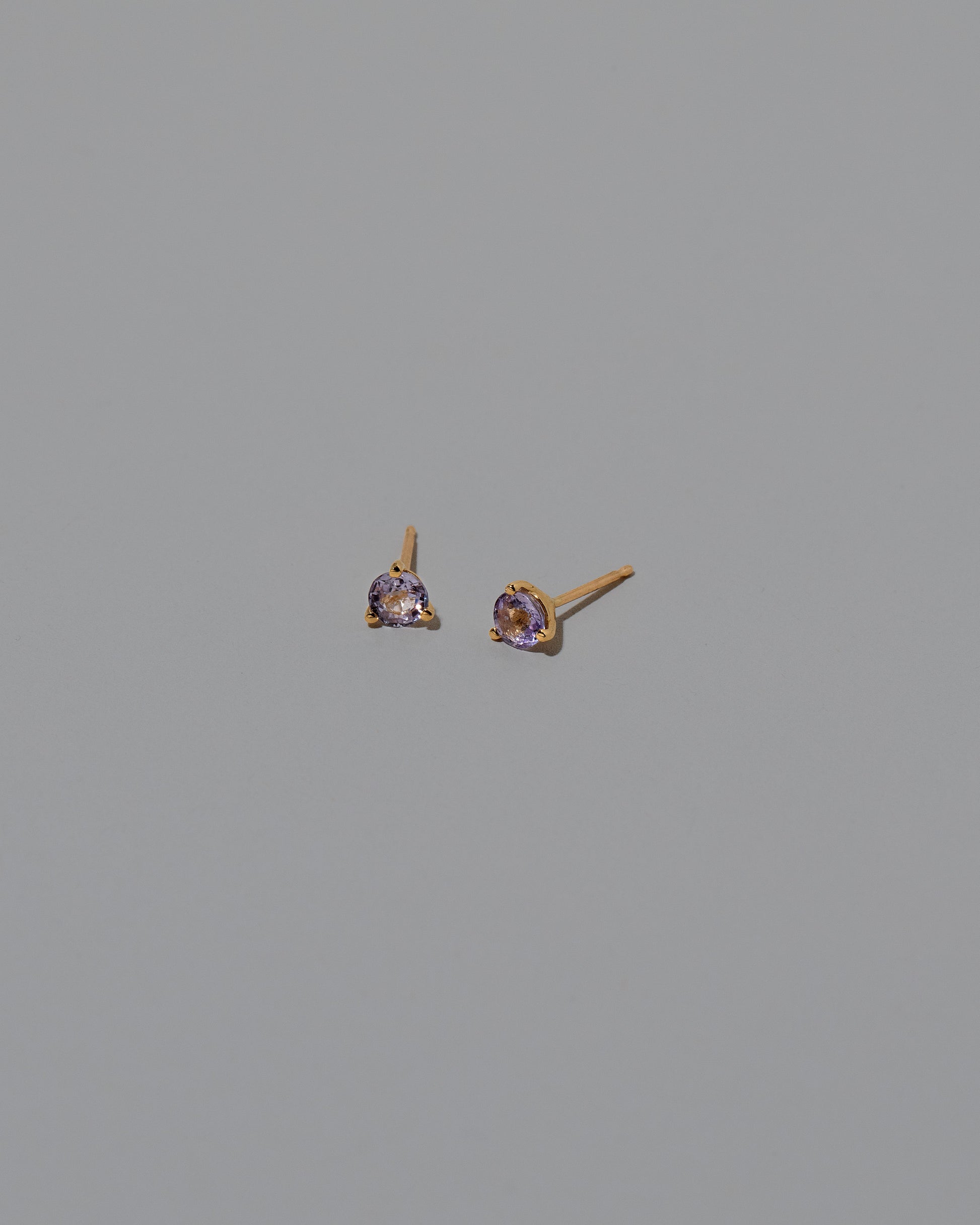 Light Lavender Sapphire Martini Stud Earrings on light color background.