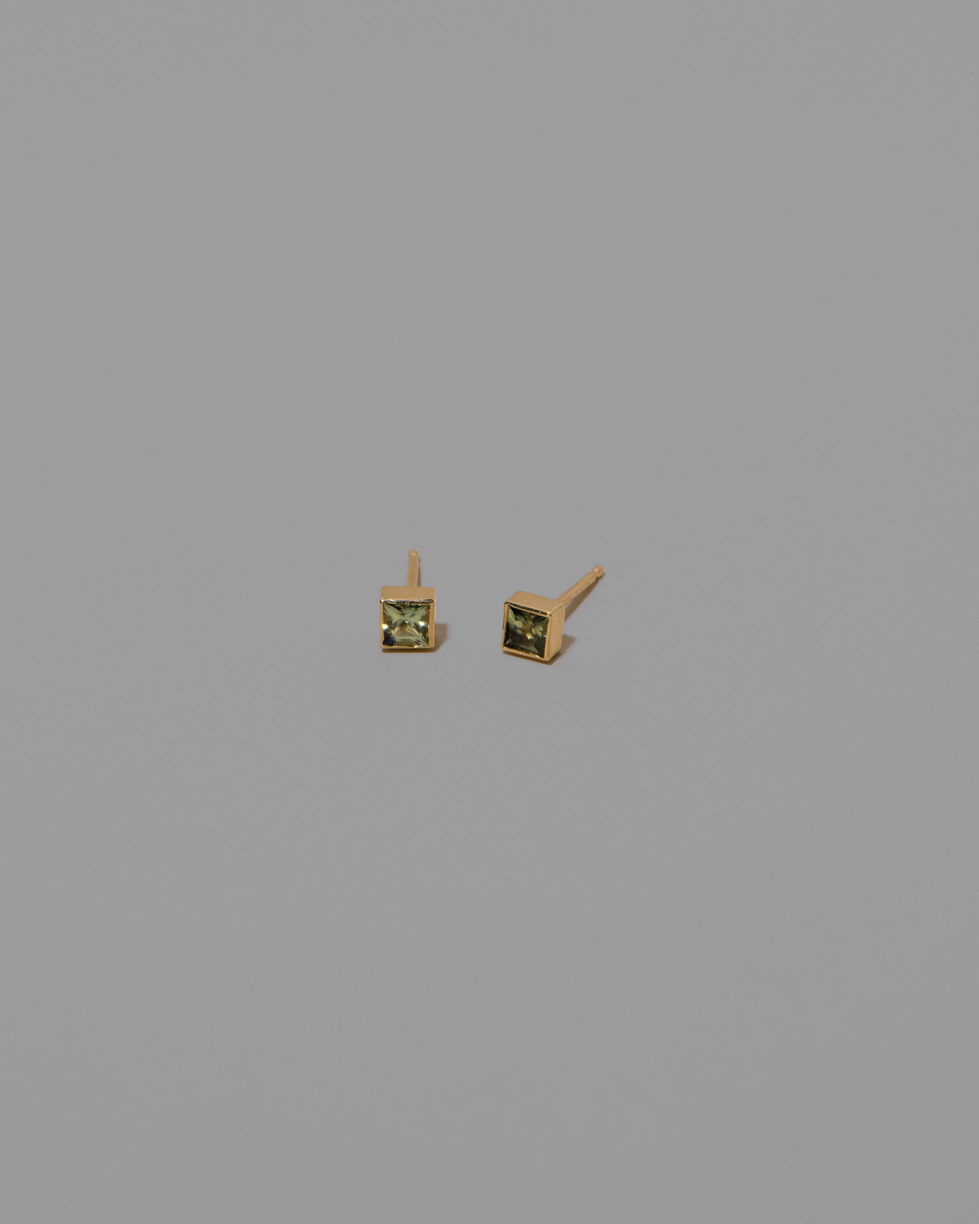 Petite Bicolor Green Sapphire Square Frame Stud Earrings on light color background.