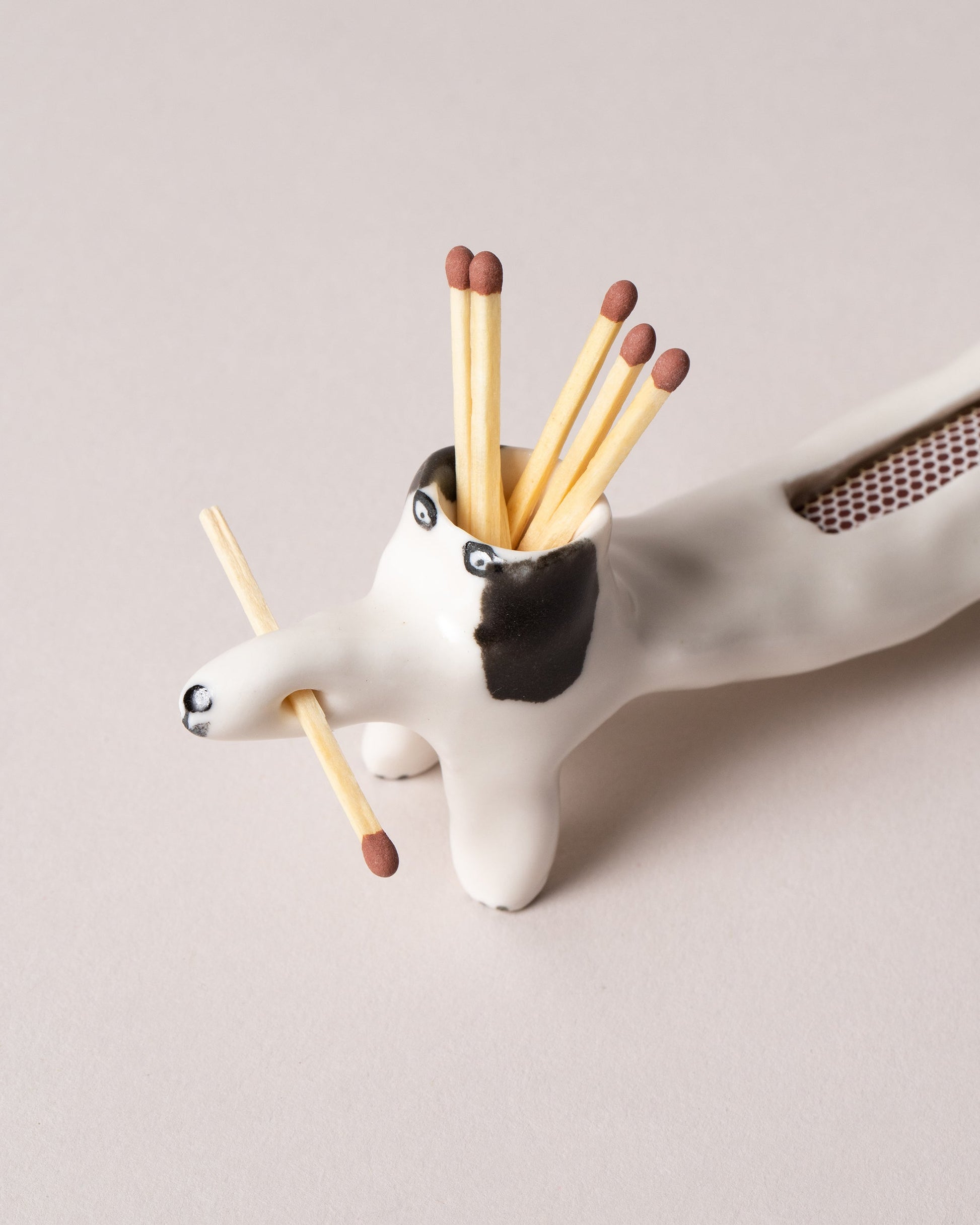 Closeup detail of the Eleonor Boström Black Matchstick Dog on light color background.