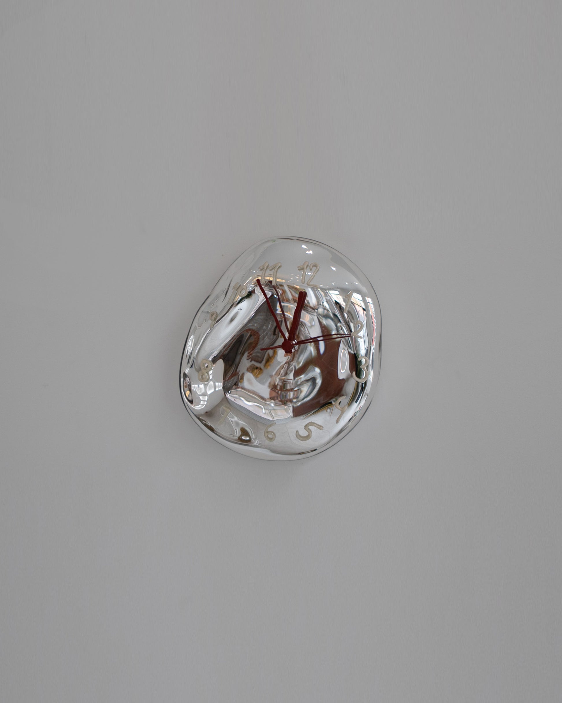 Silje Lindrup Red Hands White Glass Wall Clock on light color background.