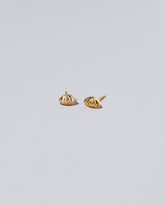 Gold Altered State Stud Earrings on light color background.