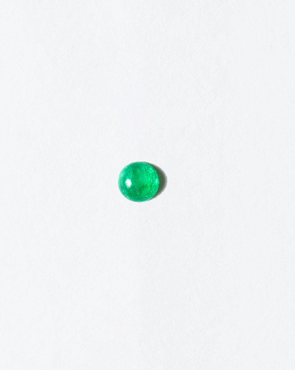 Emerald cabochon on light color background.