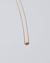 Closeup detail of the Light Pink Big Kiss Necklace on light color background.